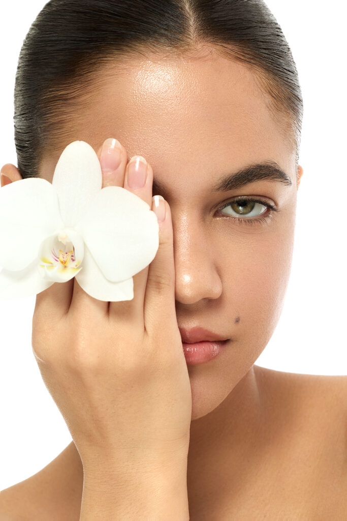 Beautyfoto mit Model und einer weißen Orchidee in der Hand.